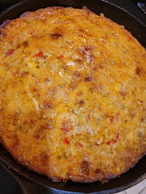 an omelet in a cast iron skillet on a stove top, ready to be cooked