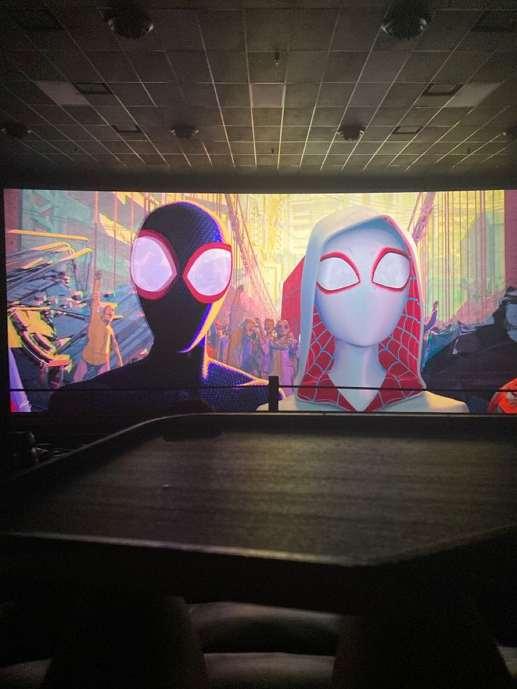 a large screen with spider man and woman on it