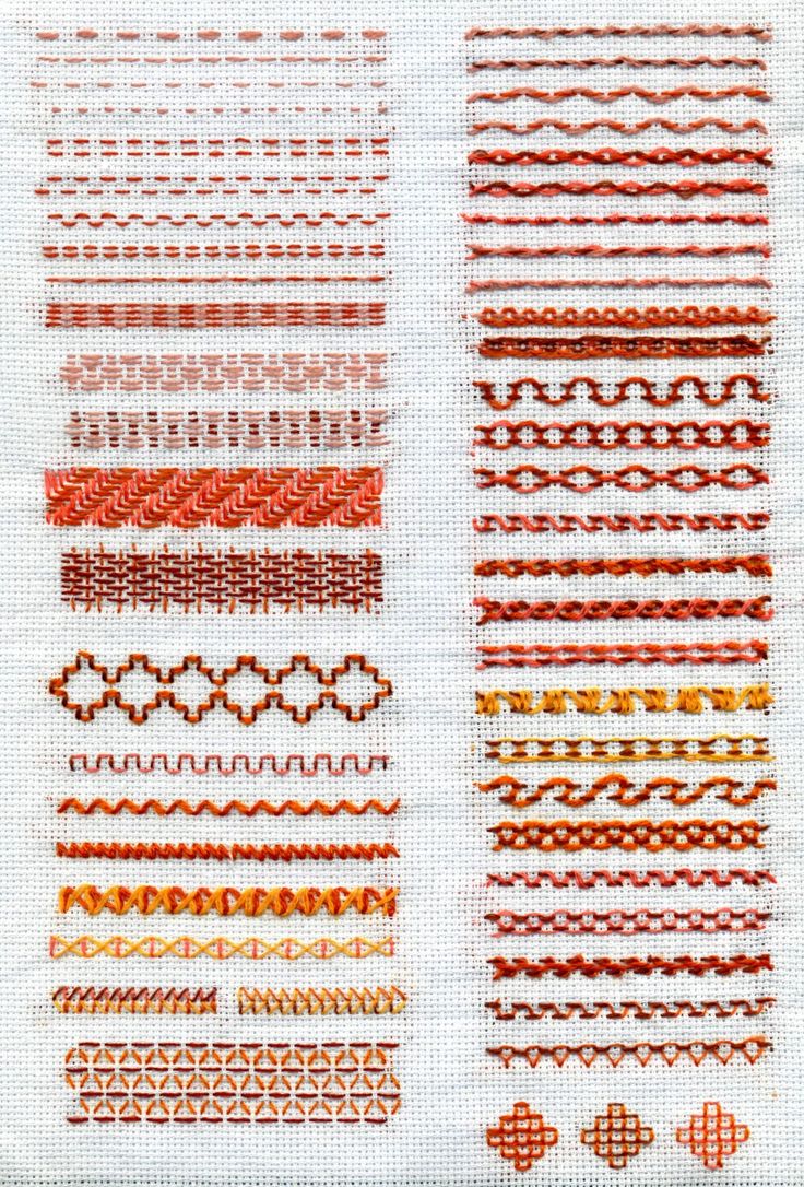 some different types of stitching on a white cloth with red and orange designs in the middle