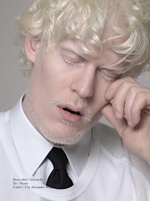 a man with blonde hair wearing a white shirt and black tie