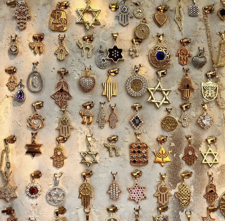 there are many different types of necklaces on the wall together in this case,