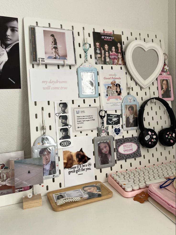 a white desk topped with lots of pictures and magnets next to a computer keyboard