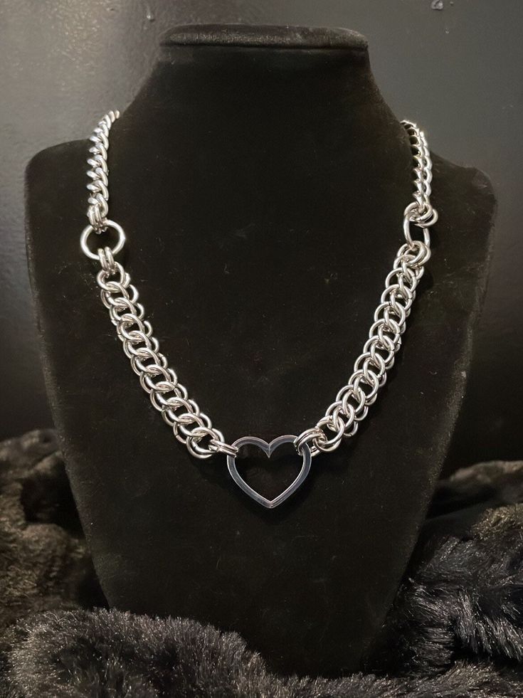 This dainty heart necklace is the perfect accessory. Whether for yourself or someone you love, this piece is made to be cherished.  Hand weaved in the half Persian Chainmaille weave and connected at the center with a Cuban chain. Made entirely from high quality stainless steel materials.  This piece is made to last a lifetime and can be worn in the shower or pool without issues.  large lobster claw clasp for closure. Length-  15 inches- choker  ( be sure to measure your neck) 16 inches- short ne Adjustable Heart Chain Necklace, Stainless Steel Chain Necklace With Heart Charm And Pendant, Silver Stainless Steel Heart Pendant Necklace, Silver Heart Chain Necklace In Stainless Steel, Stainless Steel Chain Necklace With Heart Pendant And Charm, Stainless Steel Heart Necklace As Gift, Metal Necklace With Open Heart And Adjustable Chain, Silver Double Heart Necklace With Chain, Stainless Steel Heart Necklace Gift