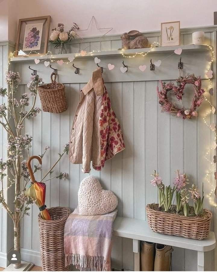 a bench with baskets and umbrellas hanging on the wall next to it is decorated with flowers