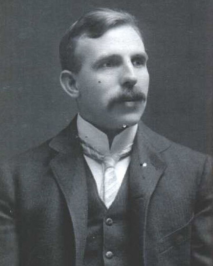 an old black and white photo of a man in a suit with a moustache