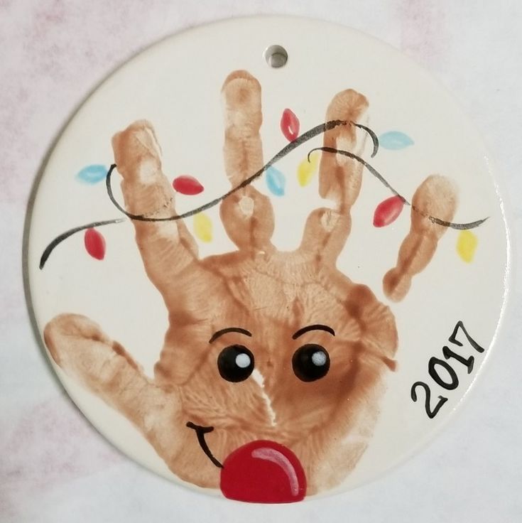 a christmas ornament with a hand print on it's face and the year 2013