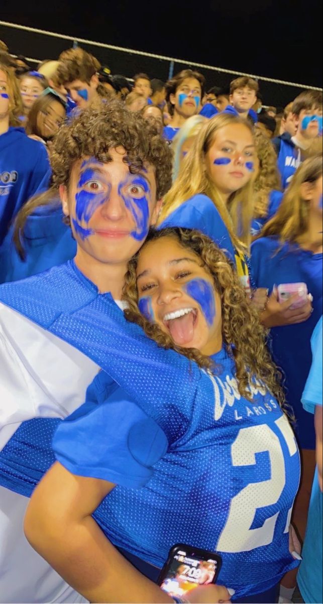 two young people with painted faces are posing for a photo in front of an audience