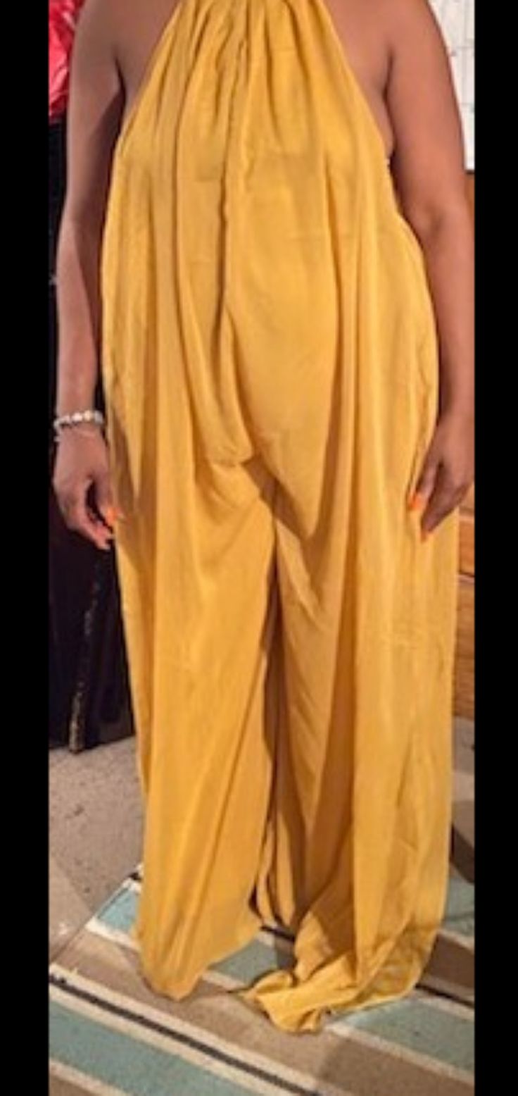 Beautiful Mustard Yellow Chiffon Backless Halter Jumpsuit. I Am 5'3, It Is Really Long On Me With About 4 Extra Inches Of Fabric. Measurements Are 36, 32, 44. Last Picture Is From The Website Where I Purchased It. Chiffon Bottoms For Summer Night Out, Summer Chiffon Bottoms For Night Out, Elegant Gold Jumpsuits And Rompers For Summer, Yellow Wide Leg Jumpsuits And Rompers For Spring, Sleeveless Gold Jumpsuits And Rompers For Summer, Gold Jumpsuits And Rompers For Spring, Chic Yellow Jumpsuits And Rompers For Party, Elegant Yellow Bottoms For Day Out, Yellow Summer Party Bottoms