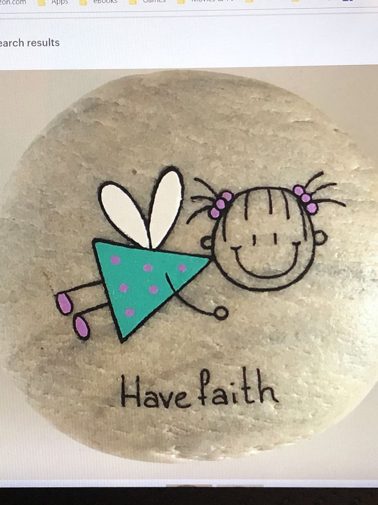 a rock with a drawing of a girl holding a blue triangle and the words have faith written on it