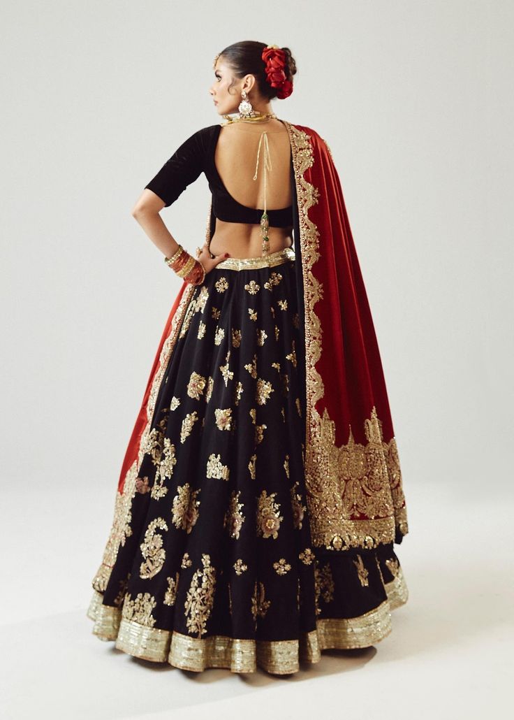 Traditional Lehenga Choli Dupatta Bridal Wedding Dress is an epitome of beauty and tradition. This stunning Lehenga choli comes in premium silk and is hand-embellished with dori, motifs, mukaish, and beads, making it your foremost priority to have a head-turning magnificent wedding look. Lehenga Choli: The choli comes in an alluring black color. The choli is in a half blouse style and it comes in premium silk fabric. The choli is beautifully adorned with shimmering embellishments and the back of Black Lehenga With Red Dupatta, Black Bridal Lehenga, Red And Black Lehenga, Lehenga Black, Dupatta Bridal, Maroon Lehenga, Traditional Lehenga, Dori Work, Choli Dress