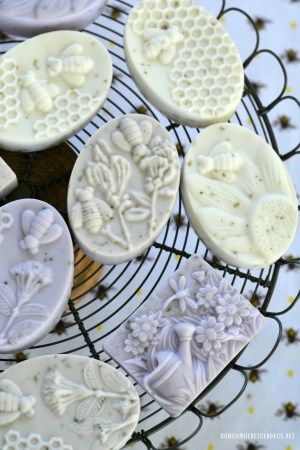 some cookies are sitting on a wire rack with bees and honeycombs carved onto them