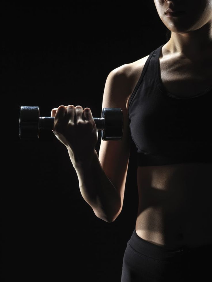 a woman holding a barbell in her right hand