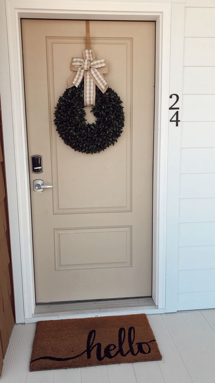 a door with a wreath on it and the word hello written in front of it