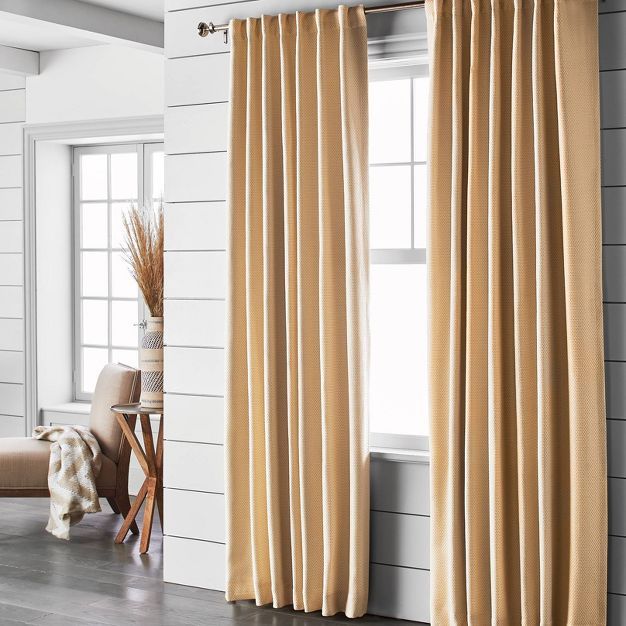 a living room with white walls and beige curtains