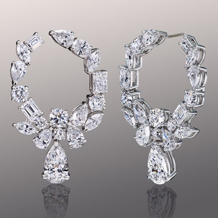 A sophisticated maximalist's choice. The juxtaposition of these earrings is unmissable when worn. The pair features a circular silhouette traced by a combination of round, pear, oval, marquise, emerald, and radiant-cut diamonds. A larger pear diamond daintily dangles like a pendant from each hoop, offering a notably sparkly finish. Diamond Statement Earrings, Luxury Marquise Cut Cluster Earrings For Formal Occasions, Luxury Marquise Cut Diamond Earrings, Modern Marquise Earrings For Formal Occasions, Luxury Marquise Cut Earrings For Formal Occasions, Timeless Marquise Earrings For Formal Occasions, Timeless Marquise Earrings For Formal Events, Luxury Marquise Cut Brilliant Earrings, Luxury Bridal Earrings Marquise With Brilliant Cut