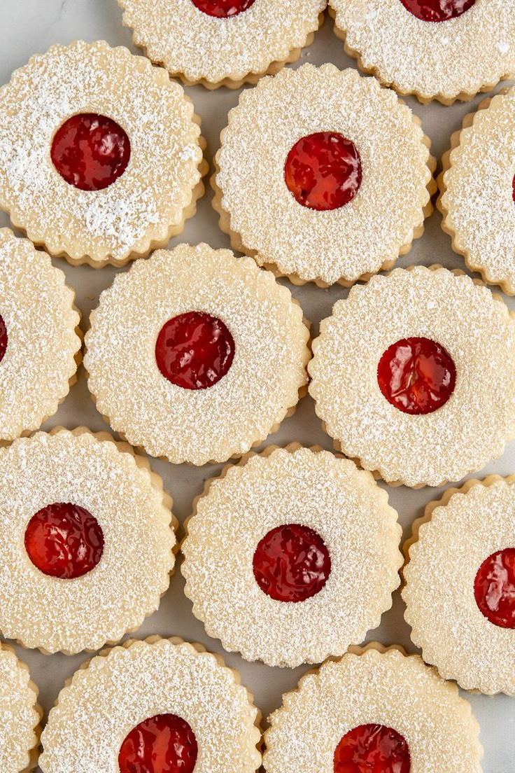 small pastries with jelly filling on them are arranged in the shape of heart - shaped pies