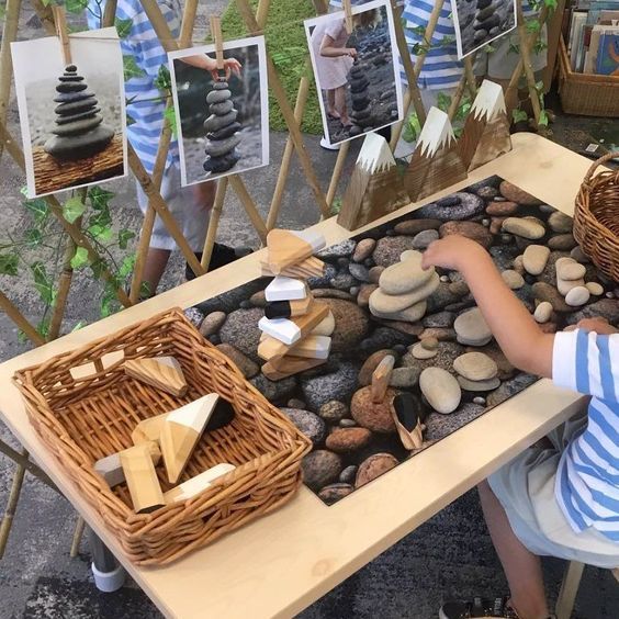 a young boy sitting at a table with rocks in front of him