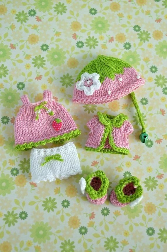 two knitted hats and one crochet baby booties on a floral background