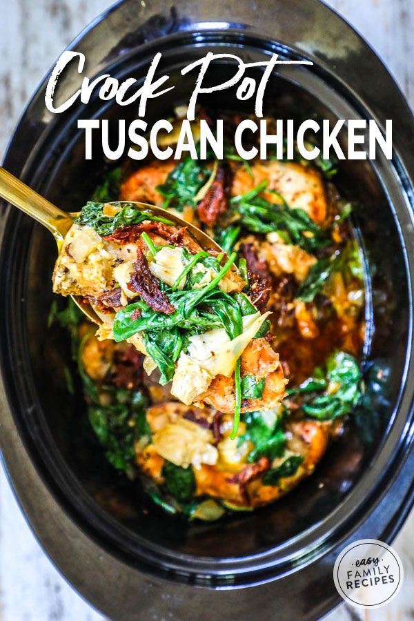 crock pot tuscann chicken in a slow cooker with a wooden spoon