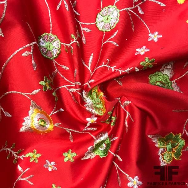 a red fabric with white flowers on it