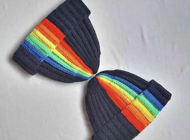 two multicolored knitted hats on white surface