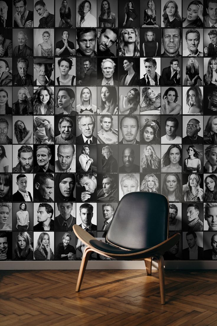 a chair sitting in front of a wall covered with many different people's heads