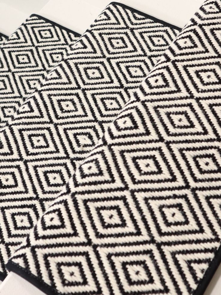 two black and white rugs sitting on top of a table next to each other