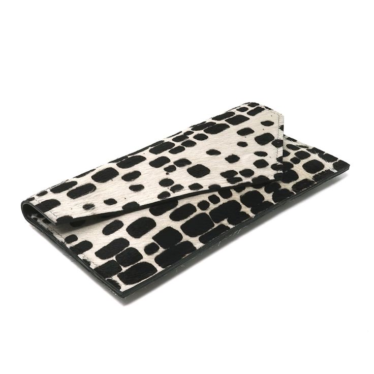 This black and white printed clutch is Ideal for carrying the essentials: sunglasses, phone, cards, cash, and keys. The black leather-lined interior features three vertical slots that provide easy access to your cards/IDs. 12"L x 6"H. Magnetic front closure.Cowhide leather lined.Printed cow hair.Slight variation in colors, patterns, and textures will occur. Embrace the beauty of this. It means every bag is truly unique. Spot clean with damp cloth. Modern White Wallet With Rfid Blocking, Chic Rectangular Wallets For Daily Use, Chic Rectangular Wallet For Daily Use, Modern Clutch With Interior Card Slots, Modern Black Rectangular Wallets, Chic Wallets With Magnetic Closure, Modern Clutch With Cell Phone Pocket, Versatile Black Clutch With Cell Phone Pocket, Modern Rectangular Clutch With Card Slots