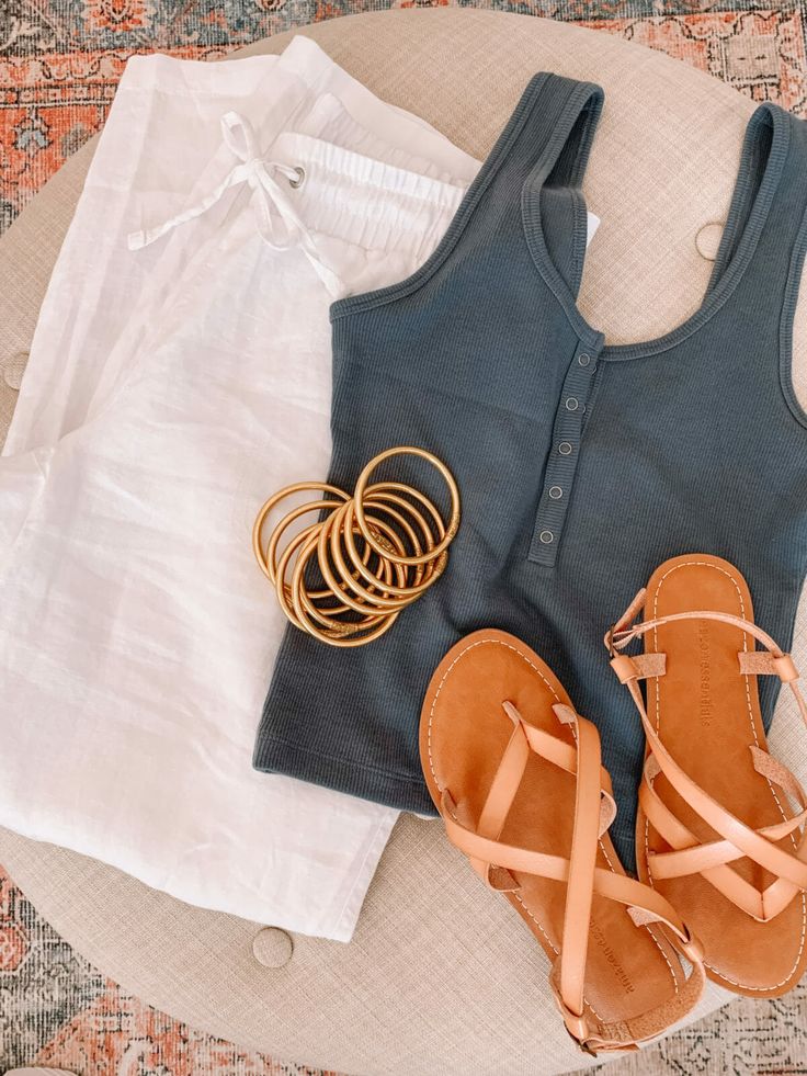 two pairs of sandals and some clothes on a table