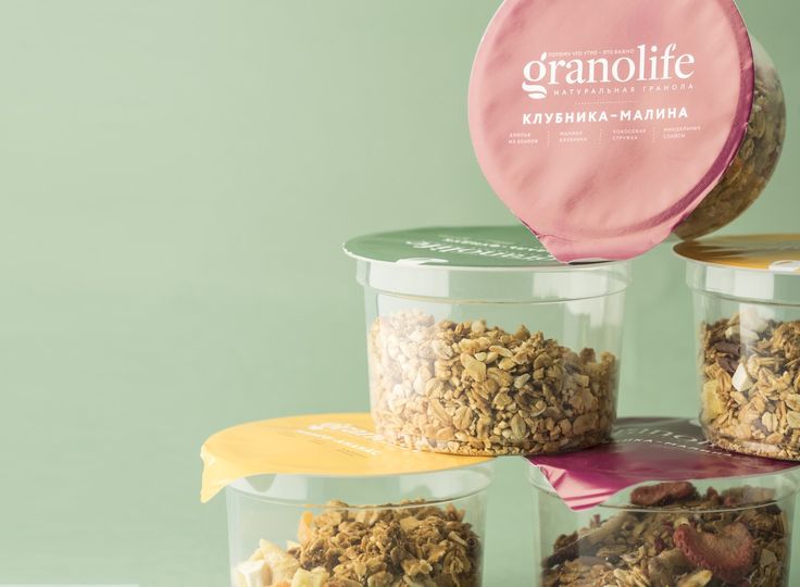 four plastic containers filled with granola sitting on top of a table next to each other