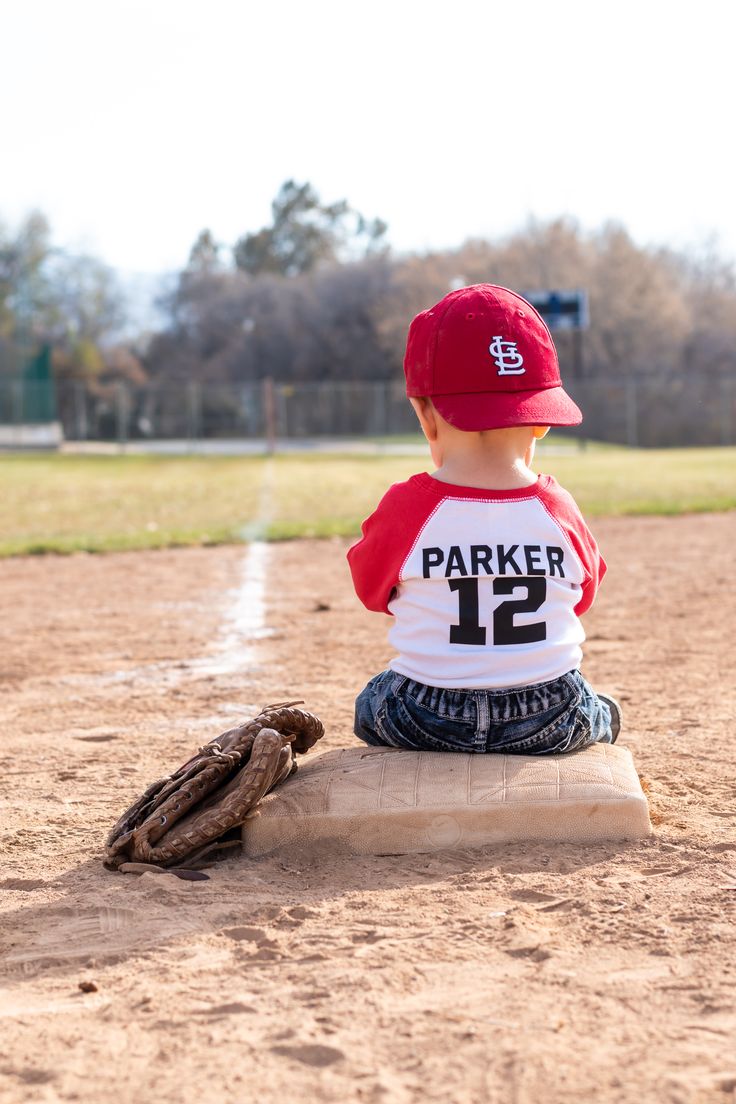 a little boy sitting on top of a base