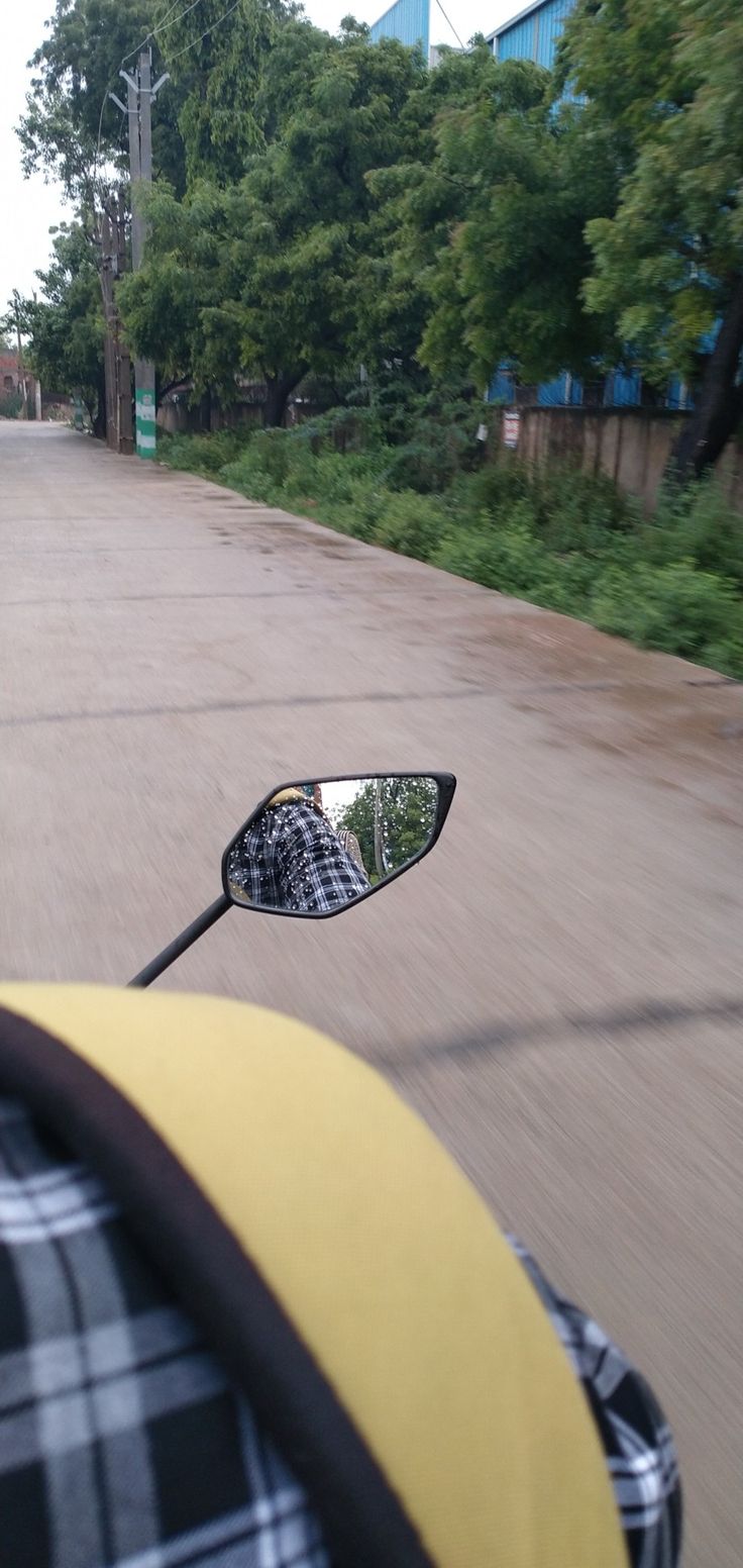 the reflection of a person's head in a side view mirror on a motorcycle