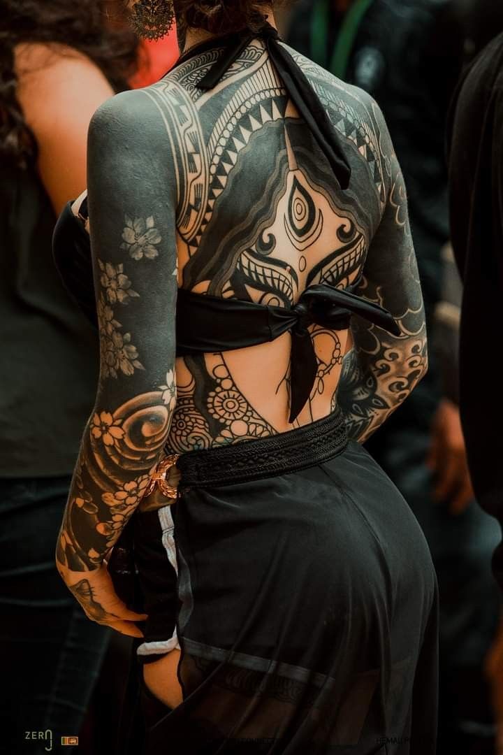 the back of a woman's body covered in tattoos