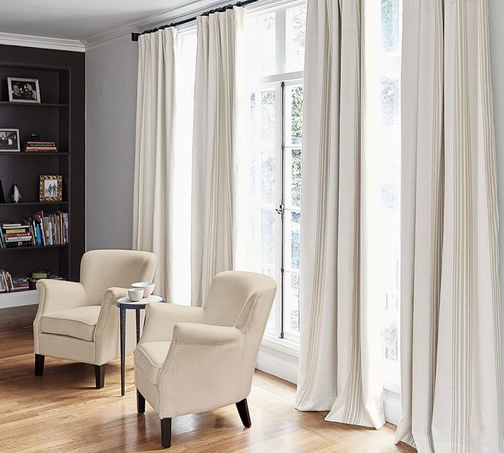 a living room filled with furniture and white curtains