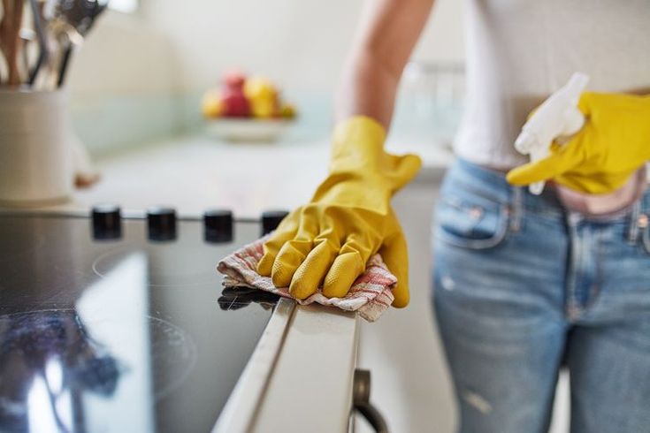 a pair of yellow gloves on top of a white counter next to a woman's legs