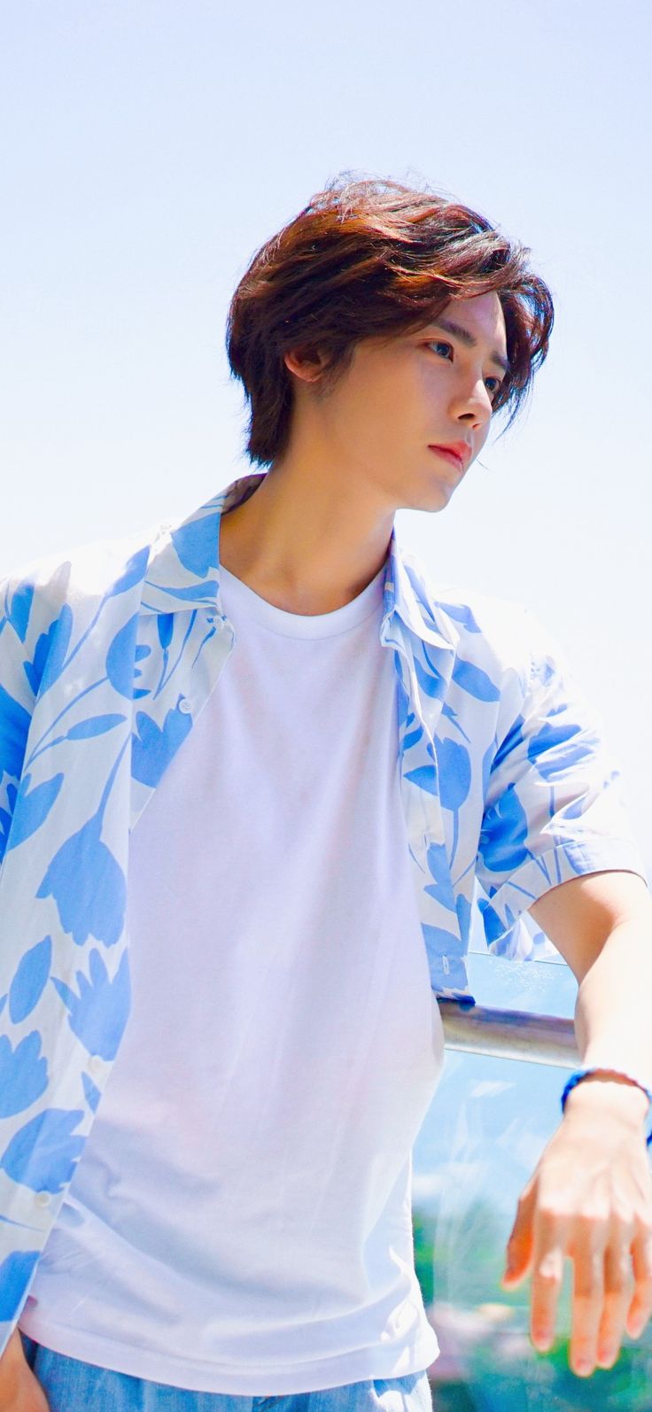 a young man standing next to a blue car