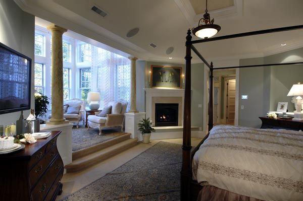 a bedroom with a bed, fireplace and stairs leading to the second floor area in front of it