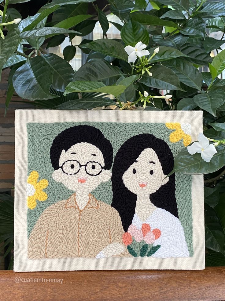 a card with two people on it next to some plants and flowers in the background