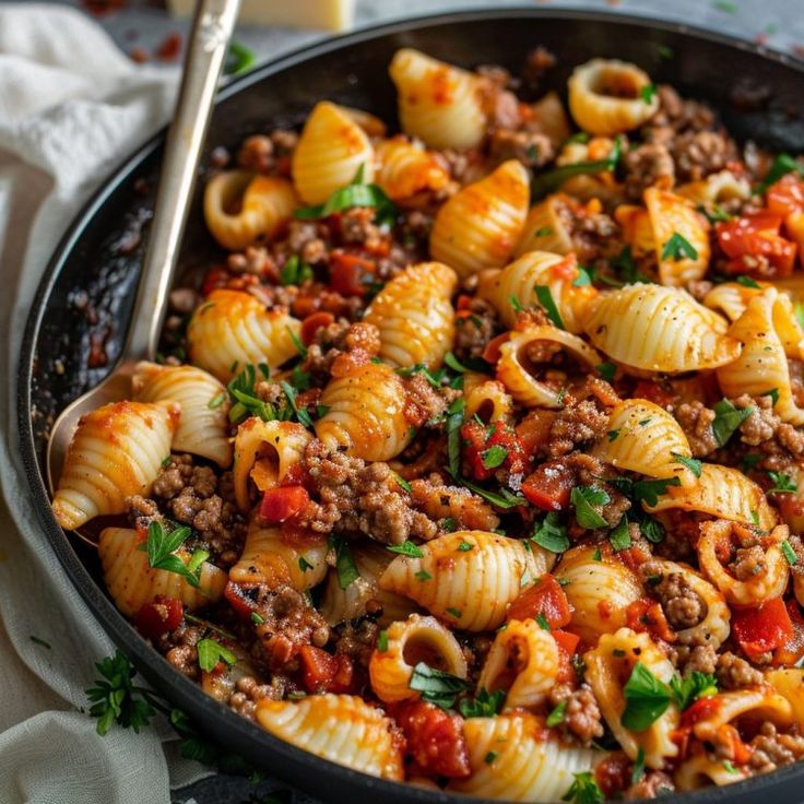 a skillet filled with pasta and meat