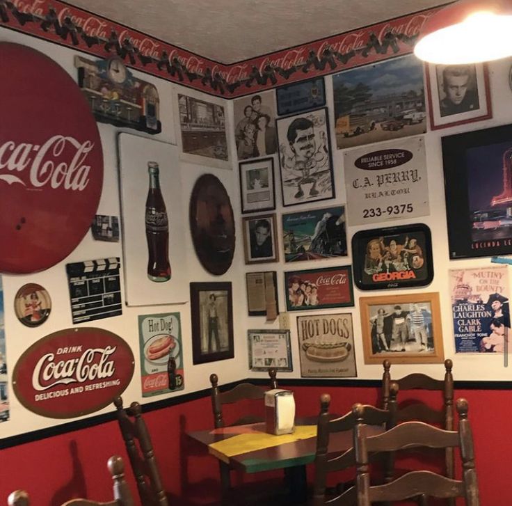 there are many coca cola signs on the wall in this diner's dining room