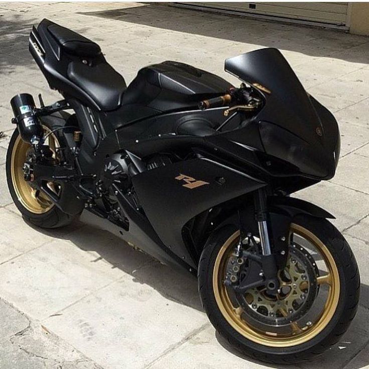 a black motorcycle parked on top of a sidewalk