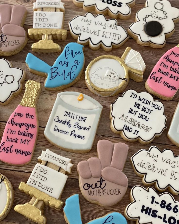 some decorated cookies with writing on them are sitting on a table next to each other