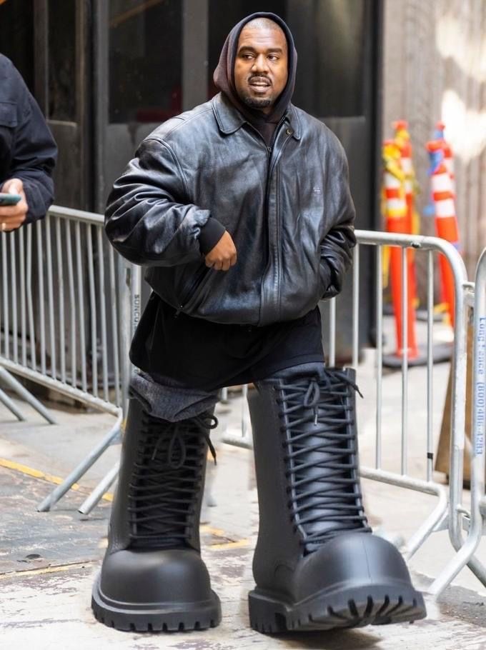 a man in black boots is walking down the street