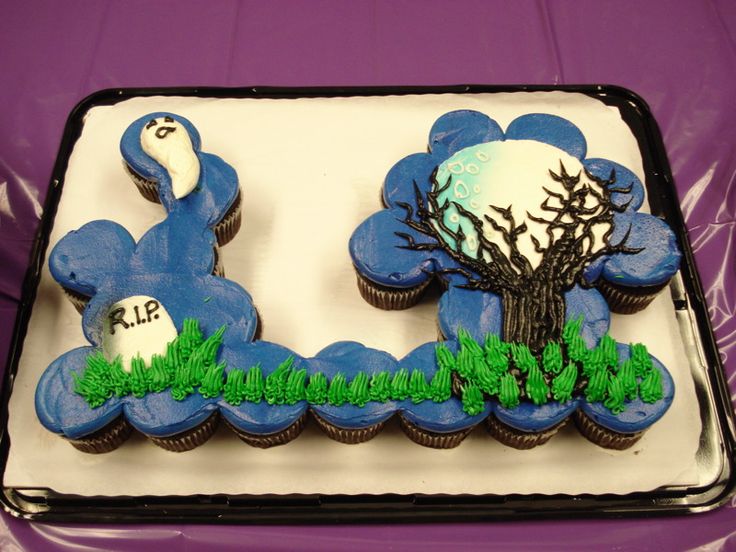 two decorated cupcakes sitting on top of a white and black tray with blue frosting