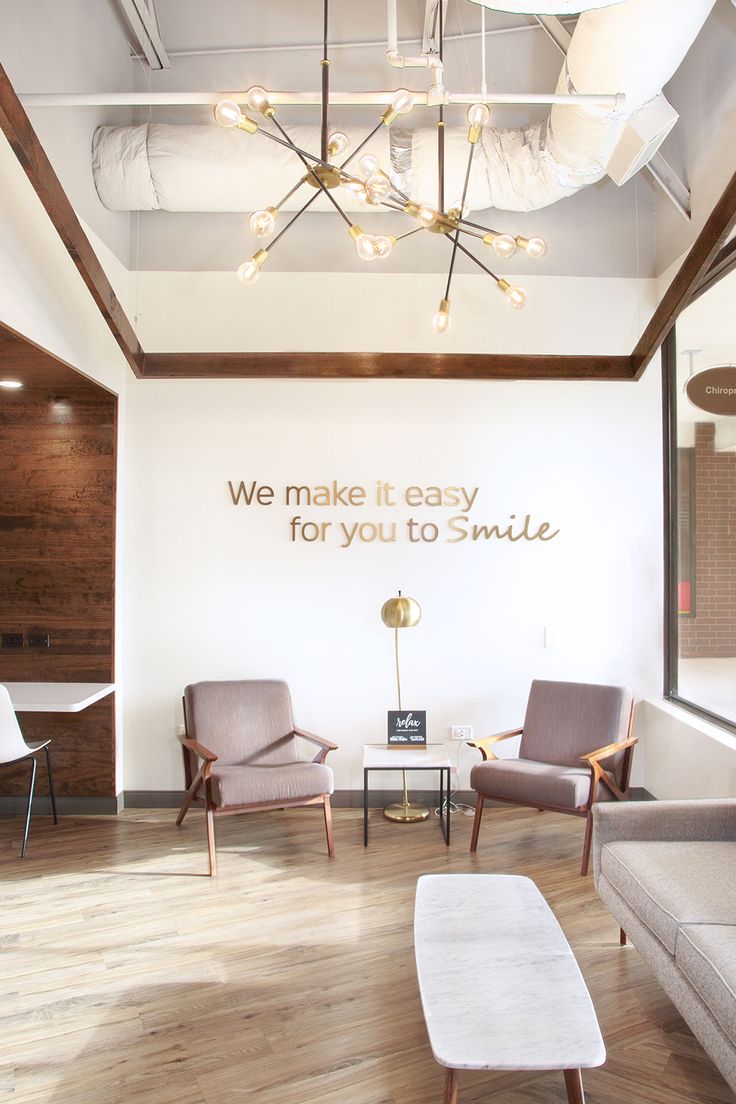 a living room with two chairs and a coffee table in front of a wall that says we make it easy for you to smile