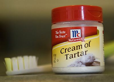 a jar of cream of tartar sitting next to a toothbrush on a counter