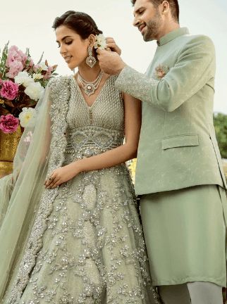 a man fixing the bride's veil on her wedding dress in front of flowers