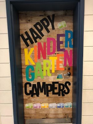 a door with the words happy kinder garden campers written on it in multicolored letters