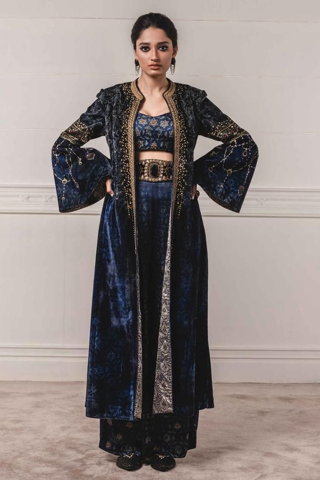 Indigo blue velvet long jacket with bell sleeves and placement dori work. Comes with printed pants and silk cropped blouse.
Components: 3
Fabric: Velvet, Modal Satin, Silk
Neckline: Round
Sleeve Length: Jacket: Full
Color: Blue
Embroidered, Printed
Front open jacket
Bell sleeves - Aza Fashions Dori Embroidery, Indigo Prints, Satin Trousers, Indigo Fabric, Tarun Tahiliani, Satin Pants, Pants Fit, Indian Fashion Designers, Velvet Jacket