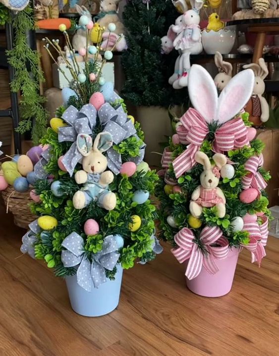 two potted trees decorated with easter decorations